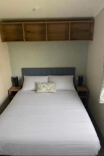 a white bed with a pillow on top of it at Luxury 3 bed sleeps 8 caravan with sea view in Exmouth