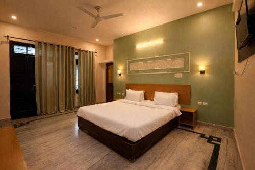 a bedroom with a bed and a ceiling fan at Heritage Inn Gomti Nagar in Lucknow