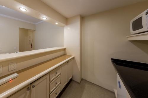 a kitchen with a sink and a microwave at Victoria Place By HX in São Paulo