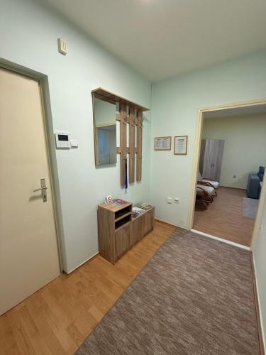 an empty living room with a door and a mirror at Apartman Ditta in Subotica