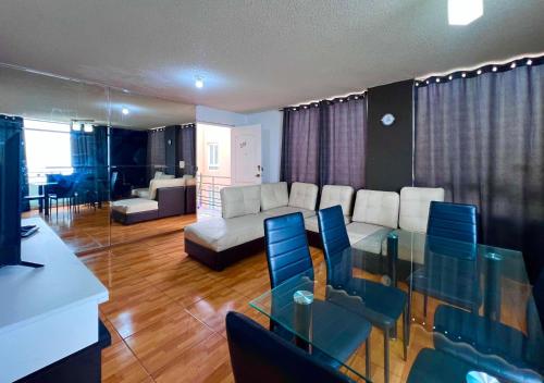 a living room with a glass table and blue chairs at Smart San Miguel in Lima