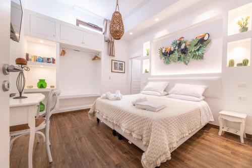 a white bedroom with a bed and a desk at Villa Icaria in Carovigno