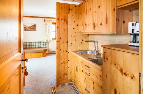 a kitchen with wooden cabinets and a sink at Reitbauernhof in Grossarl