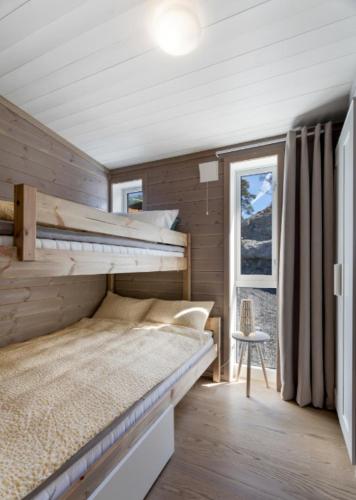 a bedroom with a bunk bed and a window at Modern cabin with panoramic views in Porsgrunn