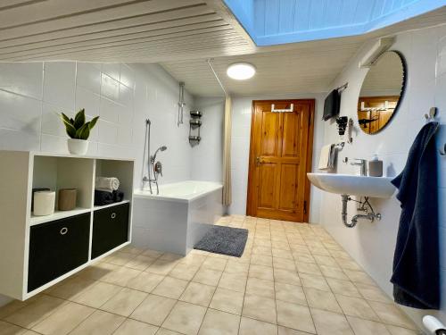 a bathroom with a sink and a tub and a toilet at FeWo Taube in Schammels dorf am Brauereienweg Platz für 7 Personen in Litzendorf
