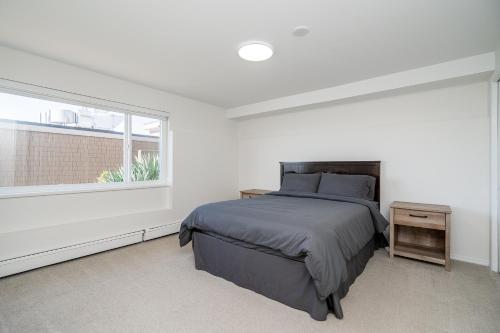 a white bedroom with a bed and a window at Oceanfront - Steps to Pier & Beach - Free Onsite Parking in White Rock