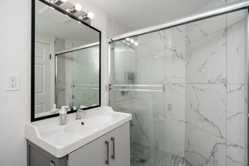 a white bathroom with a sink and a shower at Oceanfront - Steps to Pier & Beach - Free Onsite Parking in White Rock