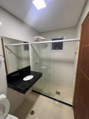 a bathroom with a glass shower and a sink at Uruguaiana House in Uruguaiana