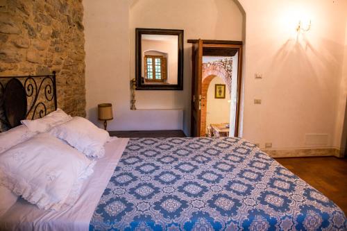 a bedroom with a bed with a blue and white quilt at Agriturismo La Romagnana in Pistoia