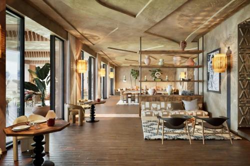a restaurant with tables and chairs in a room at Amerruk, Marrakech, Autograph Collection in Marrakesh