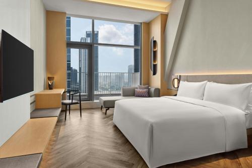 a hotel room with a large bed and a large window at AC Hotel by Marriott Hangzhou in Hangzhou