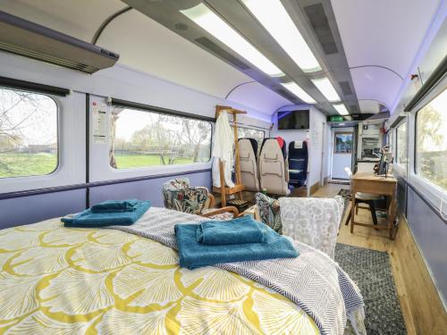 a bedroom in an rv with a bed and chairs at The Carriage Ely Paddington in Ely