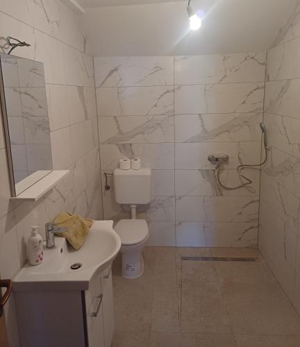a white bathroom with a toilet and a sink at Kuća za zabavu ili odmor-Pegas in Orehovica