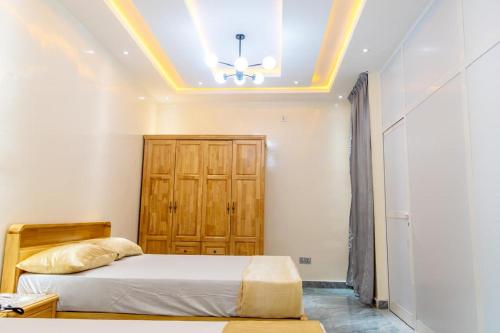 a bedroom with a bed and a wooden cabinet at Résidence Madior F2 in Dakar