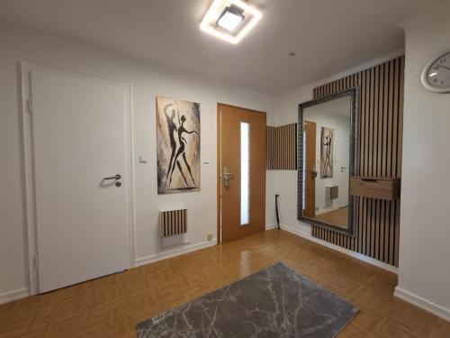 a living room with a mirror and a hallway at Ferienwohung Else Sankt Wendel in Sankt Wendel