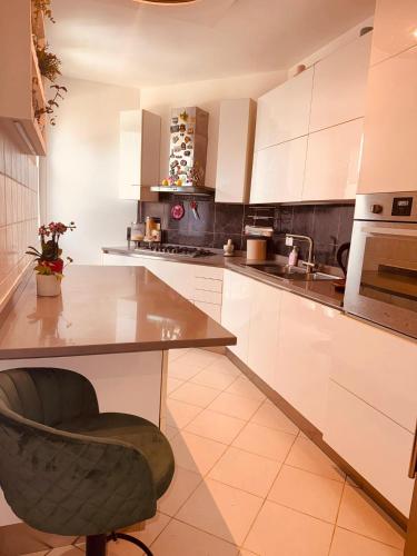 a kitchen with white cabinets and a table and a chair at Lo Scorcio su Sovicille in Sovicille