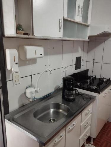 a small kitchen with a sink and a stove at Espaço Ideal 4 in Cascavel