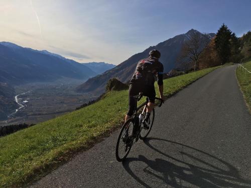 a man riding a bike down a road at Klostergut in Castelbello-ciardes