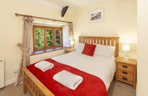 a bedroom with a large bed and a window at Old Malthouse Monksilver in Monksilver