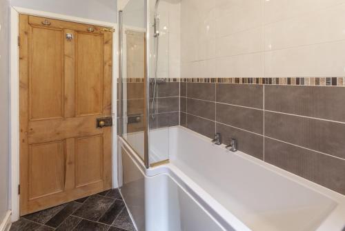 a bathroom with a bath tub and a shower at Old Malthouse Monksilver in Monksilver
