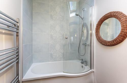 a bathroom with a shower with a tub and a mirror at Stockham Farm Dulverton in Dulverton