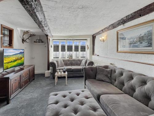 a living room with a couch and a tv at Captains Cottage Minehead in Minehead
