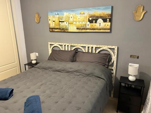a bedroom with a bed and a painting on the wall at playa ancha in San Luis de Sabinillas