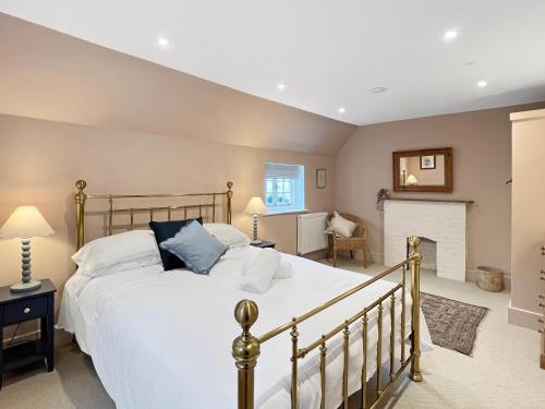 a bedroom with a large bed and a fireplace at Worthy Cottage Porlock Weir in Porlock