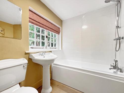 a bathroom with a tub and a sink and a toilet at Worthy Cottage Porlock Weir in Porlock