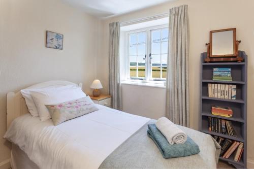 a bedroom with a bed with a window and a book shelf at Jacobs Pond Monksilver in Stogumber