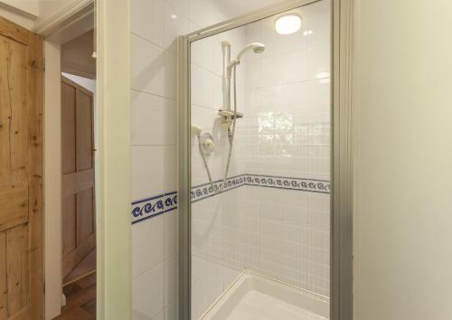 a shower with a glass door in a bathroom at Jacobs Pond Monksilver in Stogumber