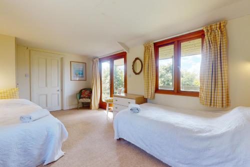 a bedroom with two beds and a window at Hillway Lodge Withypool in Withypool