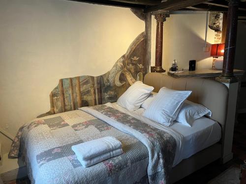 a bed with white sheets and pillows in a room at Het Kathedraalhuis Goudblomme in Antwerp