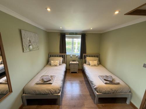 two twin beds in a room with a window at 1 Bed in Norwich oc-46293 in Brundall
