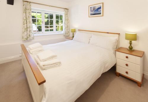 a bedroom with a large white bed and a window at Luccombe Cottage Luccombe in Luccombe