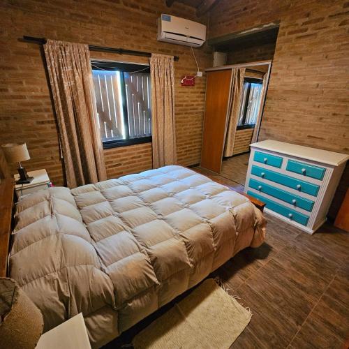 a bedroom with a large bed and a blue dresser at Cabaña Mica in Nono