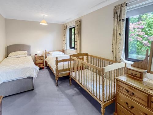 a bedroom with two beds and a crib at Merrijig Dulverton in Dulverton