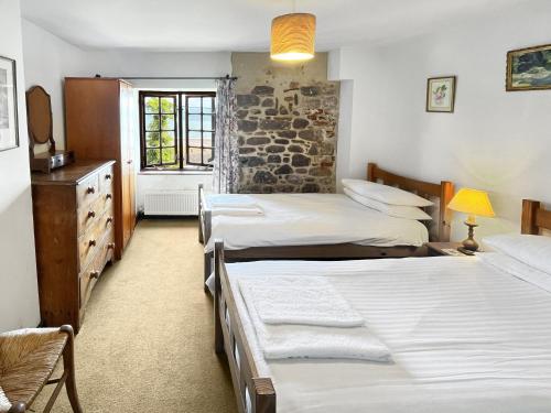 a bedroom with three beds and a window at The Crows Nest Porlock Weir in Porlock