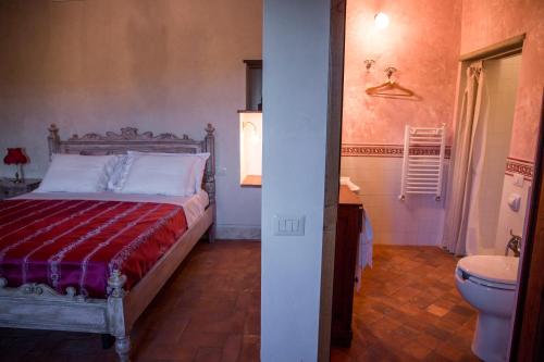a bedroom with a bed and a bathroom with a toilet at Agriturismo La Romagnana in Pistoia