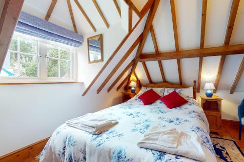 a bedroom with a bed and two windows at Little Hanger Porlock in Porlock