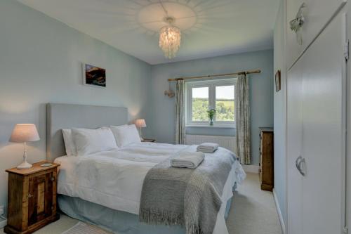 a bedroom with a large bed and a window at Linhay Cottage Withypool in Withypool