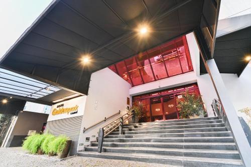 a building with stairs in front of a store at Hotel Golden Park Campinas Cambuí By Nacional Inn in Campinas