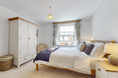 a bedroom with a large bed and a window at Bowness Porlock in Porlock
