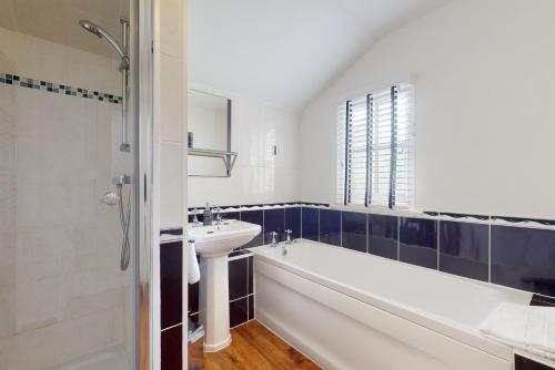 a bathroom with a sink and a bath tub and a sink at Bowness Porlock in Porlock