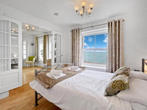 a bedroom with a large bed with a view of the ocean at Seagulls Rest Minehead in Minehead