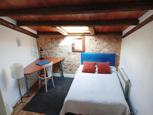 a bedroom with a bed and a desk in a room at El rincón de Atenea Tu casa cerca de Guadalajara in Aldeanueva de Guadalajara