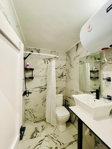 a bathroom with a toilet and a sink at Beus home in Durrës