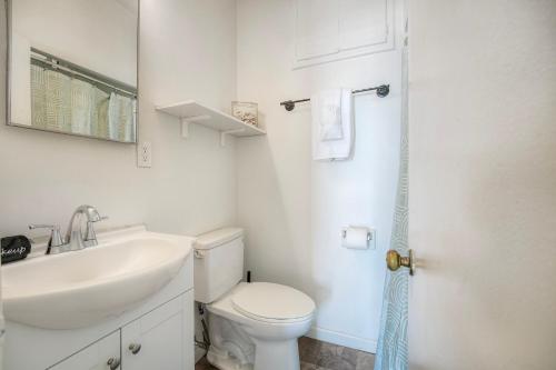 a white bathroom with a sink and a toilet at Oceanfront Condo, Private Patio, Beach Access, Sunset Views in Carlsbad