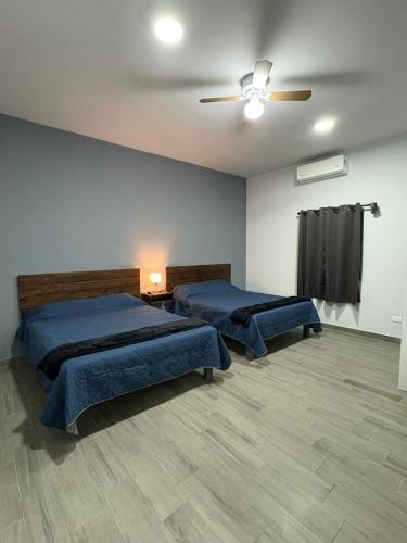 a bedroom with two beds and a ceiling fan at Los Agaves Lto in Loreto