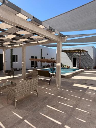 a pavilion with a swing and a swimming pool at Los Agaves Lto in Loreto